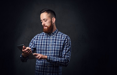 A man dressed in a blue fleece shirt holds tablet PC.