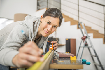 Single young woman standing by workbench at home