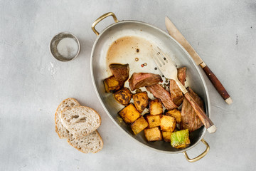 Slices steak with pumpkin in frying pan. Homemade food concept