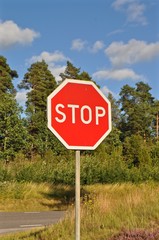 Rotes Strassenschild Verkehrszeichen "Stop" in Schweden an Autostrasse