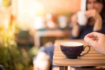 Hand greift nach Teetasse auf Tisch, am Morgen