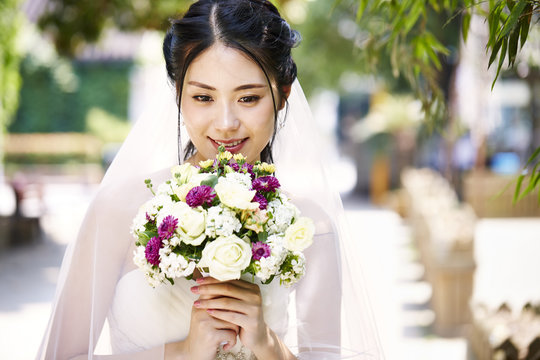 happy asian bride with flowers