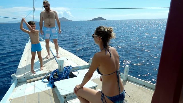 Family spending their time on the boat during vacations, slow motion shot at 240fps, steadycam shot 
