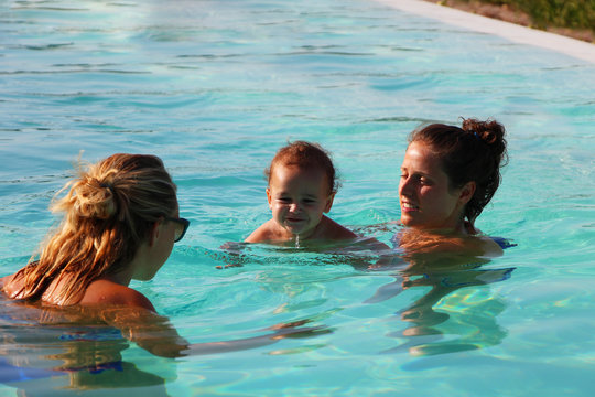 Family in swimming pool during summer 