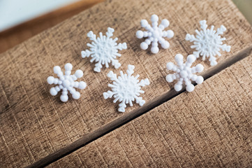 Obraz na płótnie Canvas Beautiful white plastic snowflakes close-up on a wooden background.