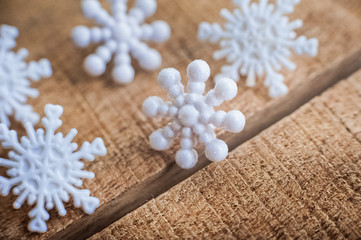 Fototapeta na wymiar Beautiful white plastic snowflakes close-up on a wooden background.