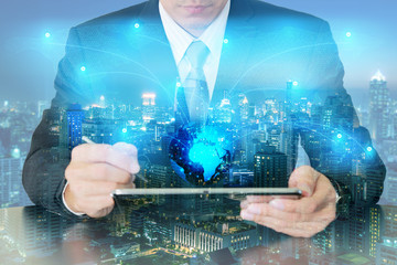 Double exposure of businessman working with tablet research around the world and light blue...