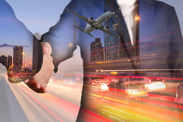 Double exposure of businessman handshake, airplane flying, light trails on street, city and urban...