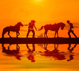 Fototapeta na wymiar silhouette cowboy and horse on blurry colorful sunset sky.