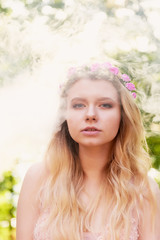 Portrait of a beautiful bride blond girl in pink lace dress ,hair decoration, handmade. Tenderness. The setting sun highlights the clouds of smoke near the face