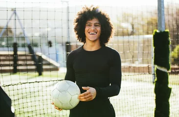 Foto op Plexiglas Teenage football player laughing on field © Jacob Lund
