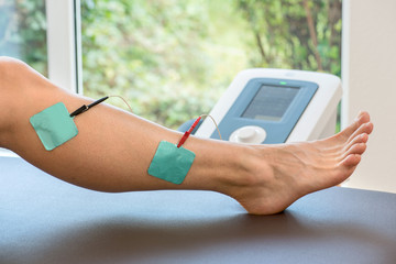 Elektromedizin in der Physiotherapie Elektroden am Bein befestigt