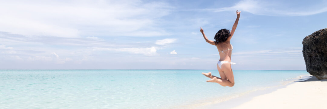 Beautiful woman relaxing on a tropical beach. Horizontal banner size, copy space photo