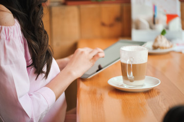 girl in cafe uses small mobile computer