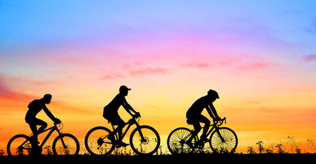 Silhouette group  bike relaxing on blurry sunrise background