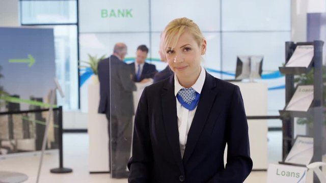  Portrait of friendly smiling financial adviser at customer help desk in bank