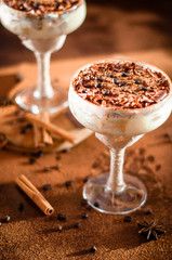 luxurious dessert Tiramisu in a glass with coffee beans on a dark background
