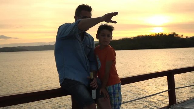 Man showing something to his son while sailing, slow motion shot at 240fps, steadycam shot
