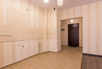 Interior of studio apartment, view from the room to the front door and kitchen without furniture