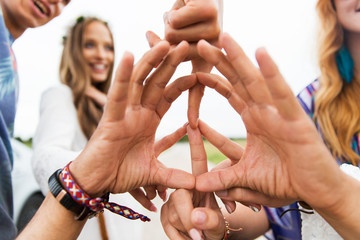 hands of hippie friends showing peace sign