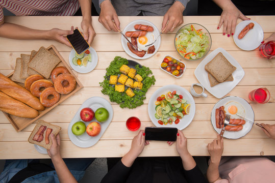 Group of happy smiling friends with smartphones taking picture of food