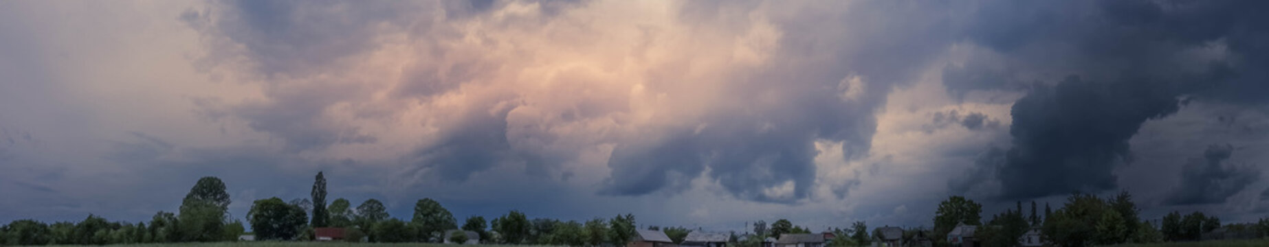 Beautiful thunderstorm clouds in dusky sky and countryside landscape