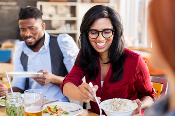 happy friends eating at restaurant