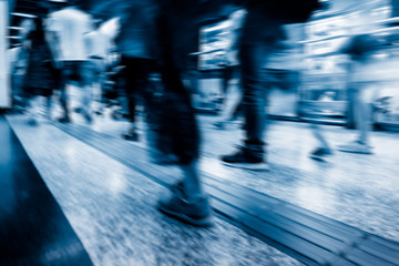 abstract blur of passengers rushing at subway station.