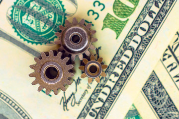metal gears on dollar banknotes