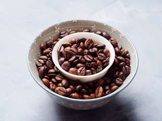 Whole Coffee beans in bowl on blue background