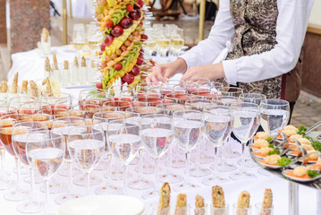 Outdoor Beautifully decorated catering banquet table with different food snacks and appetizers on...