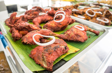 spicy fried chicken leg on banana leaf