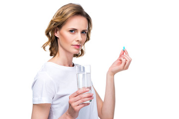 woman with glass of water and pill