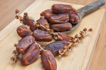 Dates palm fruits in wooden ladle on wooden background