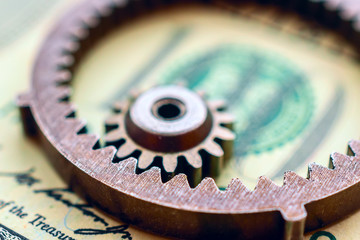 metal gears on dollar banknotes