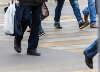 Fototapeta premium People on a pedestrian crossing. Feet and shoes, asphalt.