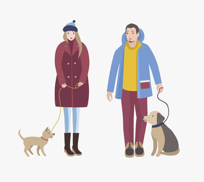 Man and woman dressed in winter clothing standing, holding their dogs in leashes and looking at each other