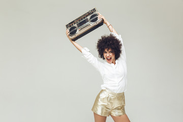Emotional retro woman dressed in shirt holding boombox.