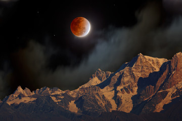 A total lunar eclipse with the red Moon at night in misty clouds over Himalayan mountains..