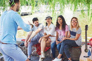 Group of friends relaxing and playing together. Young people chat on the streets, weigh and play...