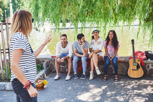 Group of friends relaxing and playing together. Young people chat on the streets, weigh and play games together