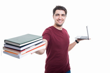 Student holding up pile of books and laptop