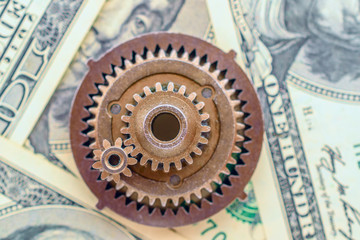 metal gears on dollar banknotes
