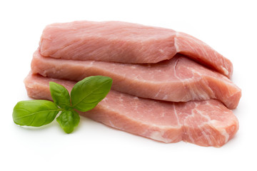 Fresh pork fillet with basil on a white background.