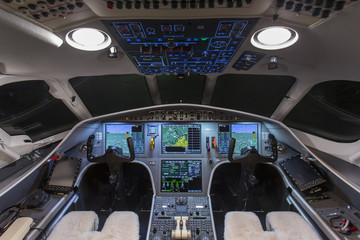 Obraz premium Instrument panels in cockpit of a very modern private business jet at night 