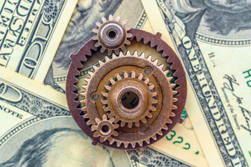 metal gears on dollar banknotes