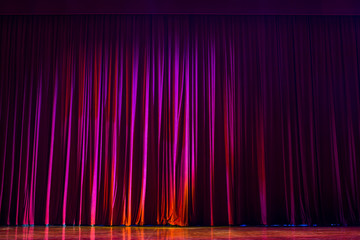 Red curtains with the lights of the show and the wood flooring parquet.