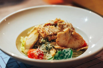 Chicken Caesar Salad. Caesar Salad with grilled chicken on plate. Grilled chicken breasts and fresh salad in plate