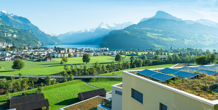 Alps and Lake Lucerne. City Brunnen. Panorama of the canton Schwyz. Residential houses, architecture. In the foreground a roof with solar panels. Small towns of Europe. Switzerland. 