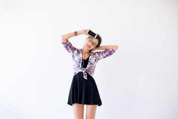 Woman in a plaid shirt in glasses plaing with headphones